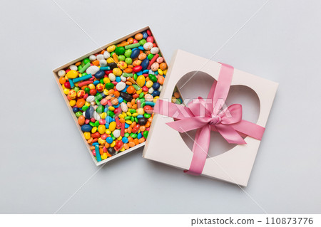 Box with sweet chocolate candies on color background, Various candy sweets. Valentines day gift box. Top view flat lay with copy space 110873776