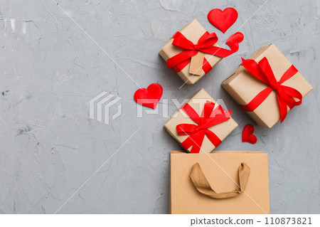 Gift boxes pop out from paper bag top view on colored background. bag packing handmade boxes fall out Concept of holidays, shopping, sale, discounts. Top view, flat lay 110873821