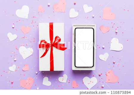 Opened gift box with ribbon and phone on color background, top view. Blank open box packaging mockup , Template for your design - branding mockup 110873894