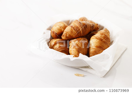 Fresh baked croissants on white table. Fresh baked croissants on white table. 110873969