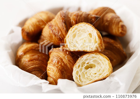 Fresh baked croissants on white table. 110873976
