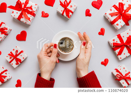 Flat lay of heart shaped cup of black coffee in the hands of women on colored background with copy space top view. Valentine day and holiday concept Flat lay of heart shaped cup of black coffee in the hands of women on colored background with copy space top view. Valentine day and holiday concept 110874020