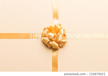 Top view of gold ribbon rolled and yellow bow isolated on colored background. Flat lay with copy space Top view of gold ribbon rolled and yellow bow isolated on colored background. Flat lay with copy space 110874021