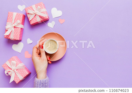 Flat lay of heart shaped cup of black coffee in the hands of women on colored background with copy space top view. Valentine day and holiday concept Flat lay of heart shaped cup of black coffee in the hands of women on colored background with copy space top view. Valentine day and holiday concept 110874023