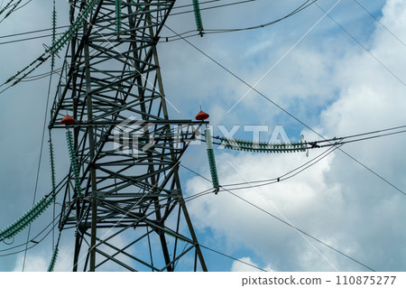 High voltage towers with sky background. Power line support with wires for electricity transmission. High voltage grid tower with wire cable at distribution station. Energy industry, energy saving High voltage towers with sky background. Power line support with wires for electricity transmission. High voltage grid tower with wire cable at distribution station. Energy industry, energy saving 110875277