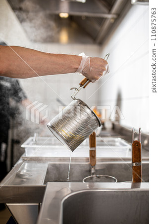 Chef drains the boiled noodles for ramen 110875763