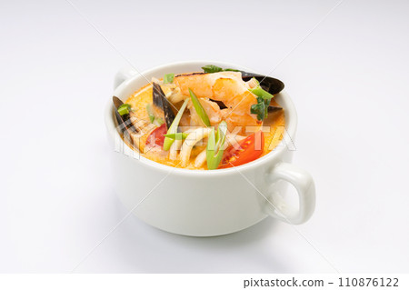 Business lunch. Tom yam soup with shrimp and mussels in a white bowl on a white background 110876122