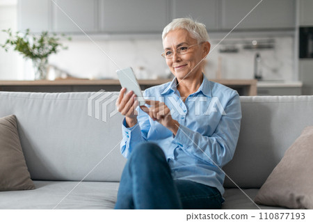 Senior Lady Wearing Eyeglasses Using Internet On Smartphone Texting Indoor Senior Lady Wearing Eyeglasses Using Internet On Smartphone Texting Indoor 110877193