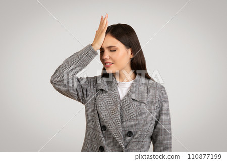 Regretful woman with hand on forehead, eyes closed in dismay Regretful woman with hand on forehead, eyes closed in dismay 110877199