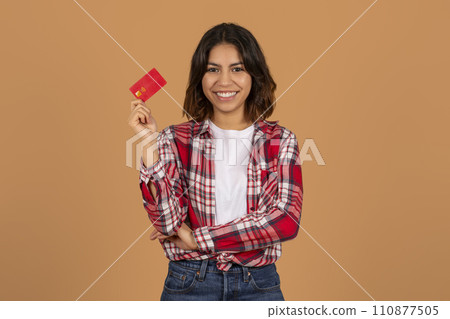 Positive young middle eastern lady showing bank credit card Positive young middle eastern lady showing bank credit card 110877505