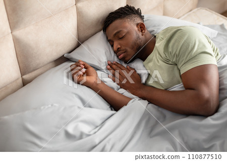 High angle of african american man lying asleep in bed High angle of african american man lying asleep in bed 110877510