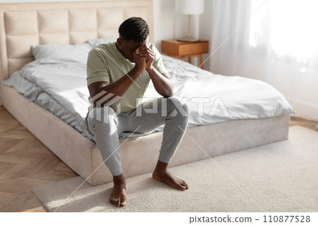 Desperate African Man Covering Face Experiencing Mental Issues In Bedroom 110877528