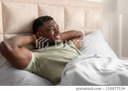 African Man Lying Awake In Bed Holding Hands Behind Head 110877534