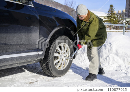 A man tightens a tire nut with a torque wrench 110877915