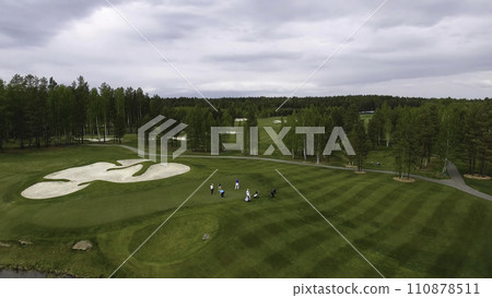 Golfers hitting golf shot with club on course while on summer vacation, aerial 110878511