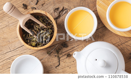 Tea leaves with teapot and tea cup on wood table, top view 110878538