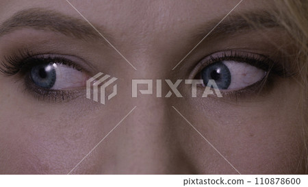 Woman with big blue eyes looks around. Close up of a woman with blue eyes. Macro of a woman's beautiful blue eyes. Extreme shallow depth of field with selective focus on center of eye. Woman with big blue eyes looks around. Close up of a woman with blue eyes. Macro of a woman's beautiful blue eyes. Extreme shallow depth of field with selective focus on center of eye. 110878600