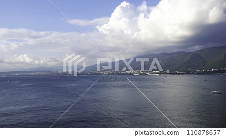 Aerial view of breathtaking blue ocean with small waves on coastal city background and mountains. Concept. Marine landscape with blue cloudy sky, concept of freedom and vacation. 110878657