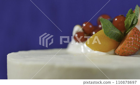Traditional Christmas fruit cake with white frosting and sugared fruits. Cream cake with kumquat, cranberries, strawberries, closeup Traditional Christmas fruit cake with white frosting and sugared fruits. Cream cake with kumquat, cranberries, strawberries, closeup 110878697
