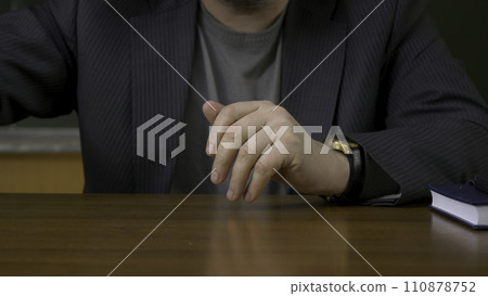Teacher sits at the table with the record book 110878752