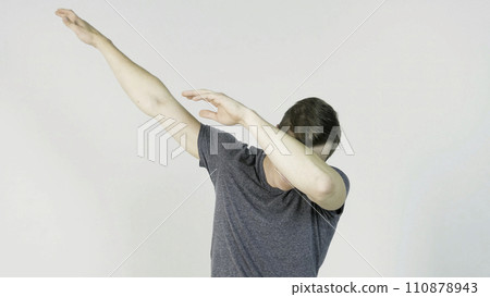 Young man makes a dab or flex it's dance move on white background 110878943