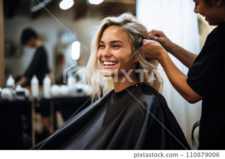 Young female hairdresser fixing hair of gorgeous smiling woman with hairspray. Hairdress and beauty concept Young female hairdresser fixing hair of gorgeous smiling woman with hairspray. Hairdress and beauty concept 110879006