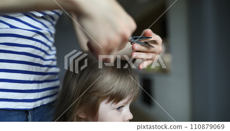 Woman doing haircut to child in an apartment 110879069