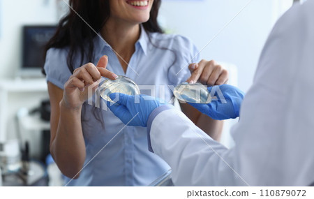 Laughing woman chooses breast implants from doctor 110879072