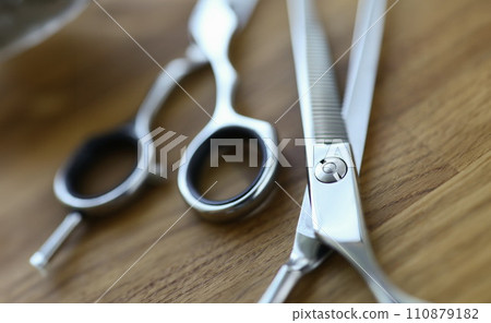Close-up, steel barber scissors are lying on table Close-up, steel barber scissors are lying on table 110879182
