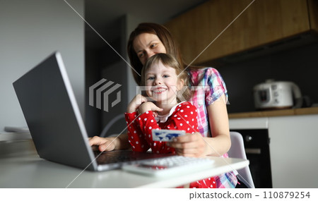 Mom and daughter kitchen enter credit card details Mom and daughter kitchen enter credit card details 110879254
