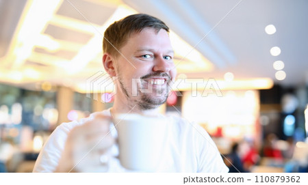 Smiling man sitting in cafe with big cup coffee 110879362