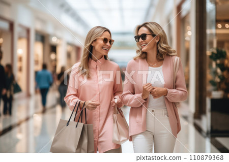 Women in shopping. Two happy women with shopping bags enjoying in shopping, having fun in the city. Consumerism, shopping, lifestyle concept 110879368
