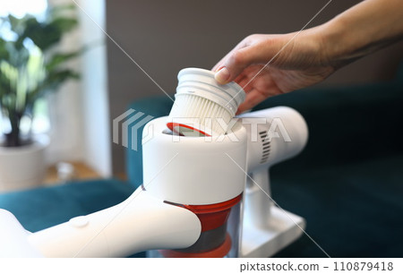 Hand takes filter out vacuum cleaner in apartment 110879418