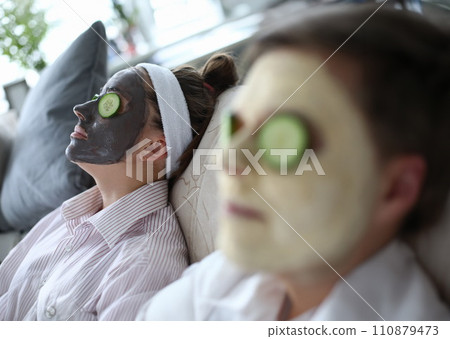 People are lying on couch with cosmetic mask faces 110879473