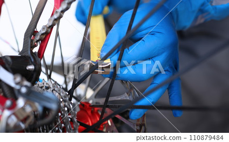 Hands measure with tape measure in bicycle wheel 110879484