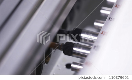 Close-up of working automatically wood drilling machine at the furniture factory. Action. Production, manufacture and woodworking industry concept Close-up of working automatically wood drilling machine at the furniture factory. Action. Production, manufacture and woodworking industry concept 110879601
