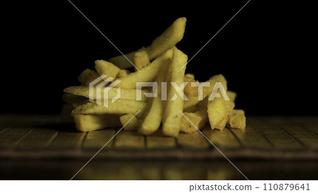Sliced Potatoes on a Cutting Board. Close up view. Delicious French fries, beautifully decorated, is on the table, concept of fast food Sliced Potatoes on a Cutting Board. Close up view. Delicious French fries, beautifully decorated, is on the table, concept of fast food 110879641