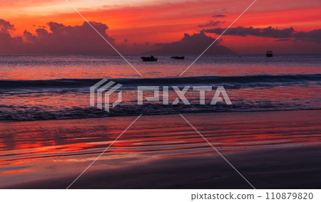Ocean shore water under red tropical sky at sunset. Mahe island 110879820
