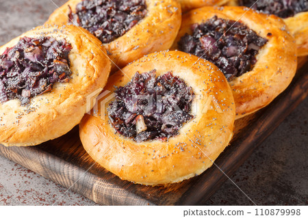 Cebularz Lubelski is a round-shaped Polish Onion poppy flatbread close-up on a wooden board. Horizontal 110879998