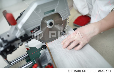 Man uses circular saw table while cutting laminate Man uses circular saw table while cutting laminate 110880323