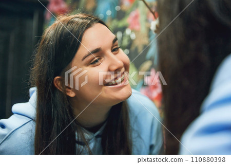 Young adult woman with braces smiling and looking at her perfect smile in bathroom mirror. Casual outfit. Young adult woman with braces smiling and looking at her perfect smile in bathroom mirror. Casual outfit. 110880398