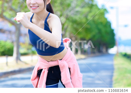 Young woman jogging, body makeup, running wear, sports bra, faceless, trimmed up 110881634