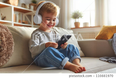 Happy smile Preteen boy kid using a smartphone and headphones for online learning, app social media, or playing a game 110881970