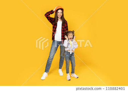 Mother and daughter in accessories for construction, on a yellow background. Mother and daughter in accessories for construction, on a yellow background. 110882401