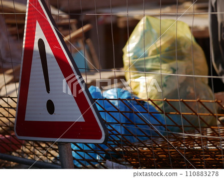 Steel reinforcement mesh and warning sign near a construction site. Rusty metal 110883278