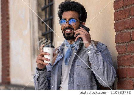 Smiling dark-haired man talking on the phone 110883778