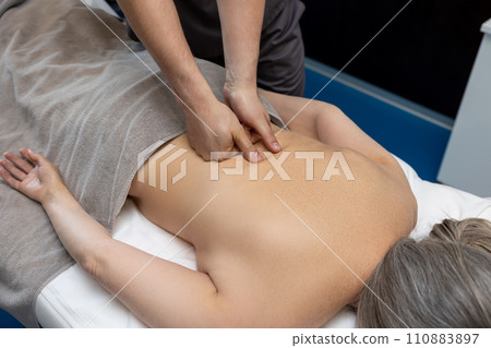 Close up of female patient having back massage in a clinic Close up of female patient having back massage in a clinic 110883897