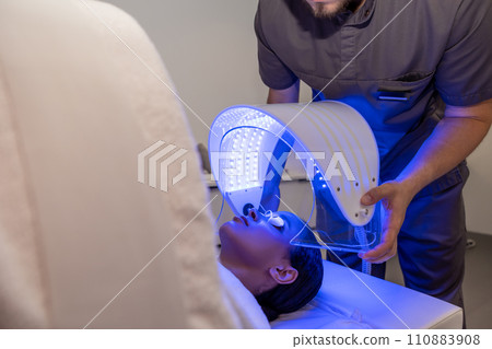 Customer in a beauty salon having a session of phototherapy Customer in a beauty salon having a session of phototherapy 110883908