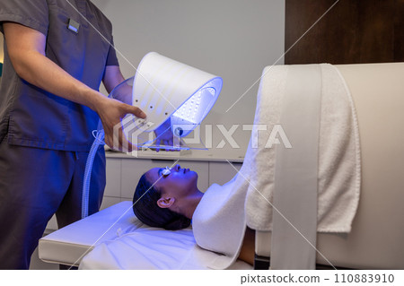 Customer in a beauty salon having a session of phototherapy Customer in a beauty salon having a session of phototherapy 110883910