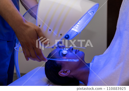 Medical specialist working with a patient during the session of phototherapy Medical specialist working with a patient during the session of phototherapy 110883925